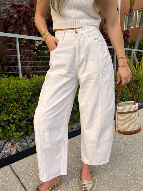 Person wearing white pants standing outdoors on a patio